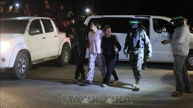 Các tay súng Hamas bàn giao nhóm con tin người Israel cho Ủy ban Chữ thập đỏ quốc tế tại Rafah, miền nam Dải Gaza, ngày 28/11/2023. (Ảnh tư liệu - minh họa: AFP/TTXVN)