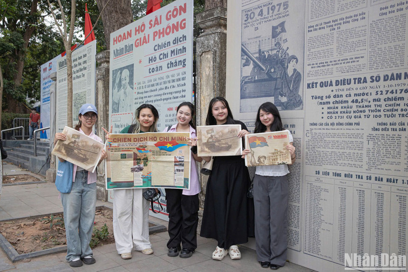 Em Hoàng Thùy Linh (thứ hai từ trái sang) cùng nhóm bạn Học viện Báo chí và Tuyên truyền cùng phụ san đặc biệt của Báo Nhân Dân. (Ảnh: SƠN TÙNG)