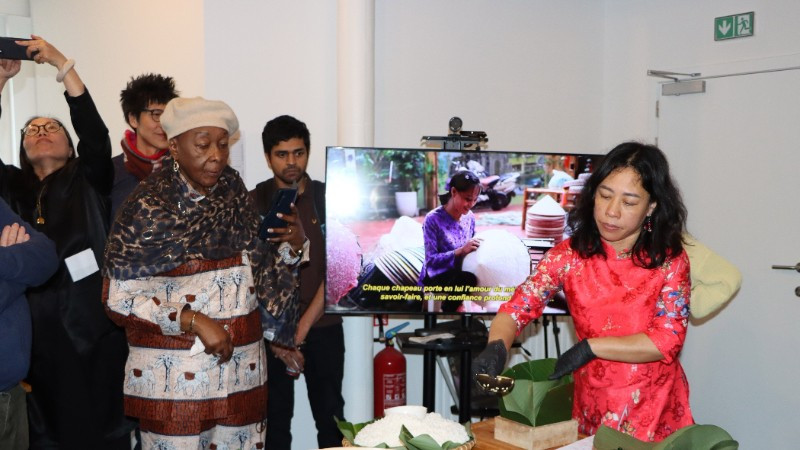 Chị Nguyễn Thị Liên, Việt kiều tại Brussels, giới thiệu cách gói bánh chưng. (Ảnh: HƯƠNG GIANG/TTXVN)