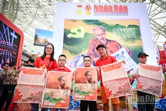 Niềm vui của một gia đình nhỏ khi xếp hàng và nhận được phụ san đặc biệt Báo Nhân Dân. Ảnh: THÀNH ĐẠT