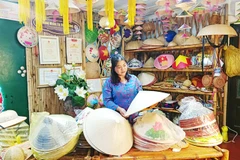 Chị Hương trong không gian trưng bày nón và giới thiệu về truyền thống làm nón làng Chuông.