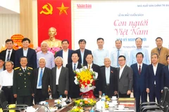 PGS, TS Nguyễn Hồng Vinh (cầm hoa) cùng các đại biểu, đồng nghiệp chụp ảnh lưu niệm trong lễ ra mắt sách.