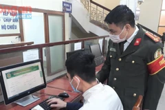 Cán bộ Phòng Quản lý xuất nhập cảnh, Công an tỉnh Nghệ An hướng dẫn người dân hoàn thành các thủ tục hành chính.
