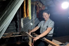 Người dân bản biên giới Cha Nga, xã Mỹ Lý tranh thủ dệt thổ cẩm khi có ánh sáng điện ổn định.