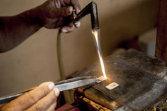 Công nhân đang nung chảy thỏi bạc để làm trang sức bạc tại Cơ sở trang sức bạc HS Silver ở Kotagede, Yogyakarta, Indonesia. (Ảnh: Xinhua)