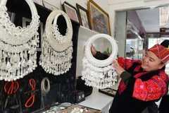 Thợ thủ công giới thiệu các sản phẩm trang sức bạc tại một cửa hàng bạc ở tỉnh Quý Châu, tây nam Trung Quốc. (Ảnh: Xinhua)