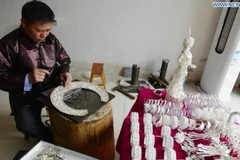 Thợ thủ công chế tác trang sức bạc tại một cửa hàng bạc ở tỉnh Quý Châu, tây nam Trung Quốc. (Ảnh: Xinhua)