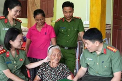 Đại tá Trần Hồng Quang, Phó Giám đốc Công an tỉnh Nghệ An ân cần thăm hỏi sức khỏe Mẹ Việt Nam Anh hùng Nguyễn Thị Năm. (Ảnh: CÔNG AN NGHỆ AN)