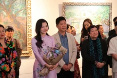 Họa sĩ Lê Trang (áo dài tím) tại triển lãm.