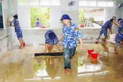 Kéo bùn dọn dẹp phòng học. Ảnh: HẢI LUẬN