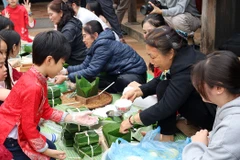 Các bạn nhỏ học cách gói bánh chưng.