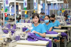 Công nhân nữ làm việc hứng khởi tại cơ sở sản xuất của Tổng công ty Cổ phần Dệt may Hà Nội (Hanosimex).