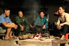 Anh Thò Bá Của (thứ hai, từ trái sang) và cán bộ Đồn Biên phòng Tri Lễ tuyên truyền quy định về bảo vệ đường biên, cột mốc tới dân bản.