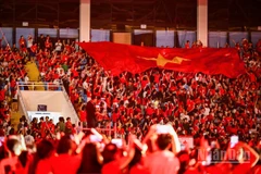 Khoảnh khắc lá cờ Tổ quốc được chuyền tay trên khán đài. (Ảnh: THÀNH ĐẠT)