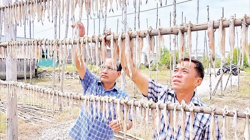 Chủ một cơ sở sản xuất kiểm tra chất lượng sản phẩm.