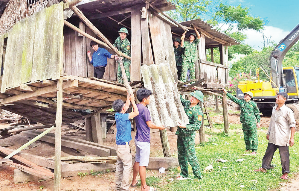 Bộ đội Biên phòng cùng thanh niên tình nguyện và các hộ dân ở xã biên giới Dân Hóa, huyện Minh Hóa tháo dỡ các mái nhà dột nát để làm nhà mới.
