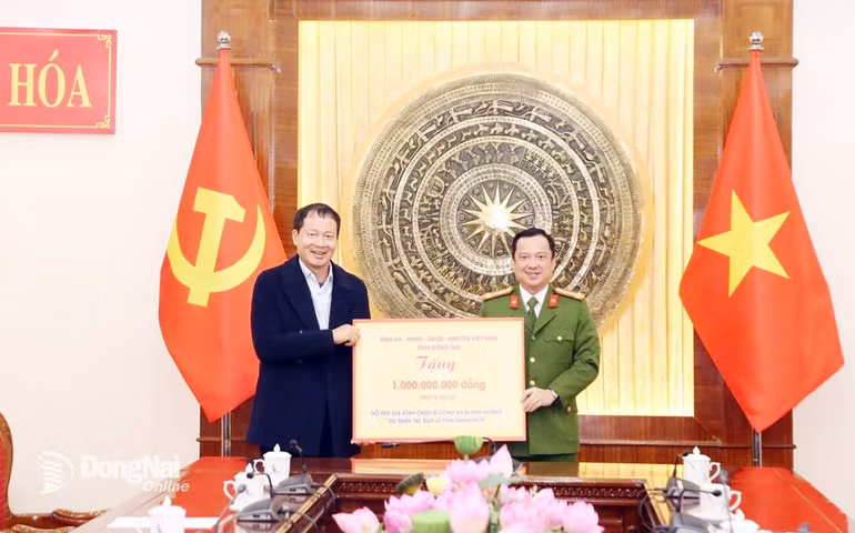 Đồng chí Vũ Hồng Văn, Bí thư Tỉnh ủy, Trưởng đoàn Đại biểu Quốc hội tỉnh Đồng Nai trao biểu trưng số tiền hỗ trợ gia đình chiến sĩ Công an bị ảnh hưởng do thiên tai, bão lũ. (Ảnh: PHONG SẮC)