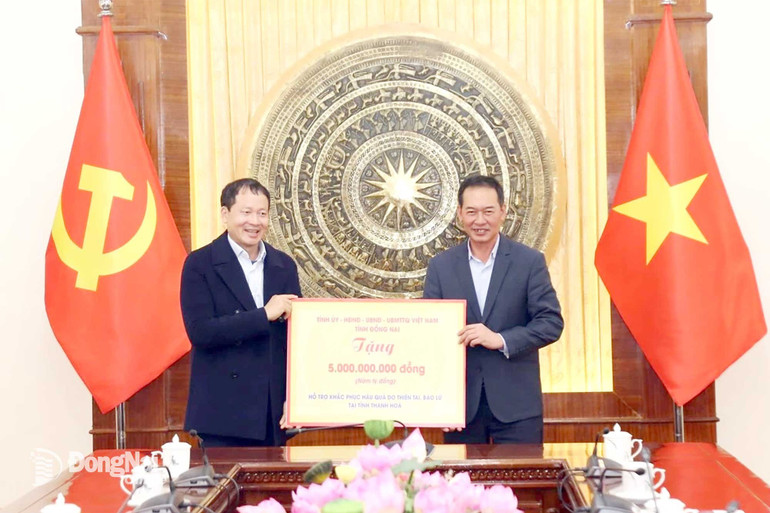 Đồng chí Vũ Hồng Văn, Bí thư Tỉnh ủy, Trưởng đoàn Đại biểu Quốc hội tỉnh Đồng Nai trao biểu trưng số tiền hỗ trợ nhân dân Thanh Hóa khắc phục thiệt hại do thiên tai, bão lũ gây ra. (Ảnh: PHONG SẮC)