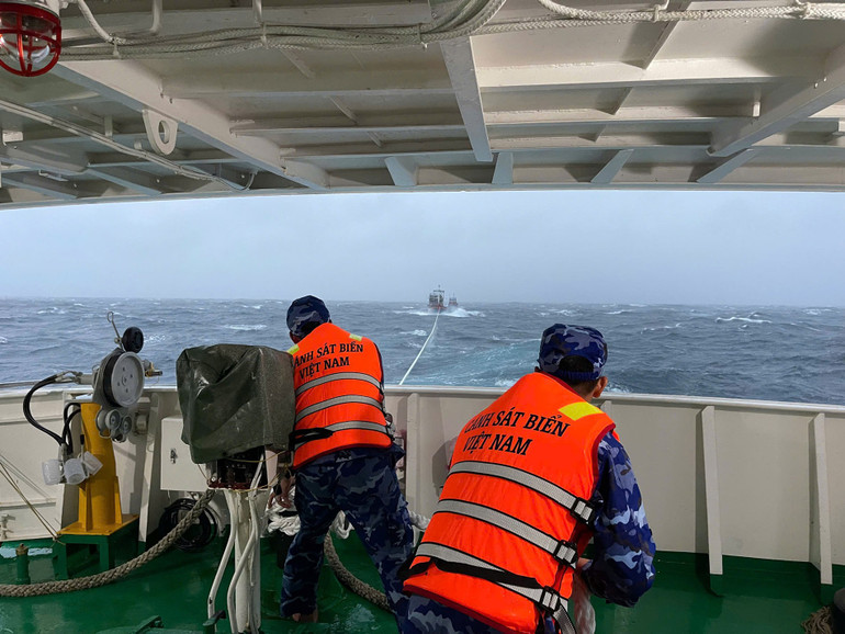 Ett fartyg från kustbevakningens region 2-kommando bogserade den nödställda fiskebåten till Ly Son-ön. (Foto: NAM TRUNG) 4.jpg