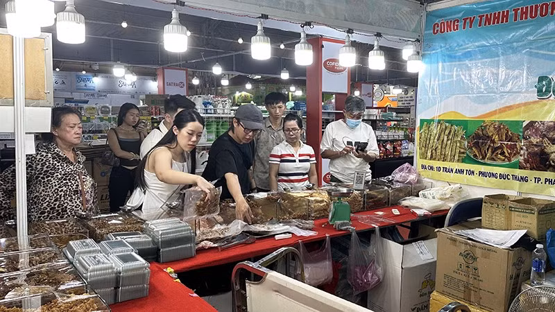 Khách du lịch nước ngoài tham quan và mua sắm hải sản khô tại một gian hàng trong chiều ngày 17/11.