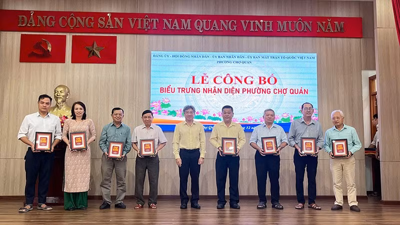 Lãnh đạo phường Chợ Quán tặng bộ ấn phẩm biểu trưng nhận diện phường đến các cơ quan, đơn vị trên địa bàn.