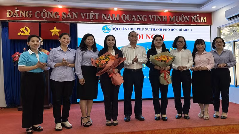 Đại diện Thành ủy và Ủy ban nhân dân thành phố tặng hoa chúc mừng bà Nguyễn Thị Ngọc Xuân (thứ tư từ phải sang).
