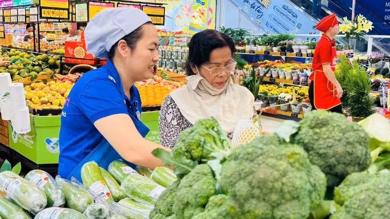 Người dân mua rau xanh bình ổn thị trường trong một siêu thị Co.opmart ở Thành phố.