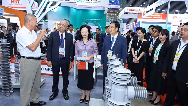 Các đại biểu và khách tham quan một gian hàng tại triển lãm.