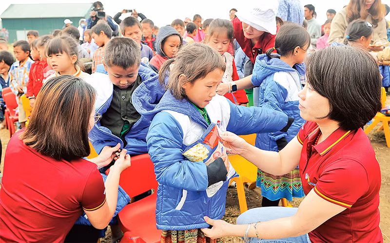 Cán bộ, đoàn viên thanh niên Công ty Du lịch Vietravel tặng áo ấm cho học sinh điểm Trường tiểu học Tọt Còn, xã Cao Thượng, huyện Ba Bể (Bắc Kạn).Ảnh: Nguyễn Ðăng