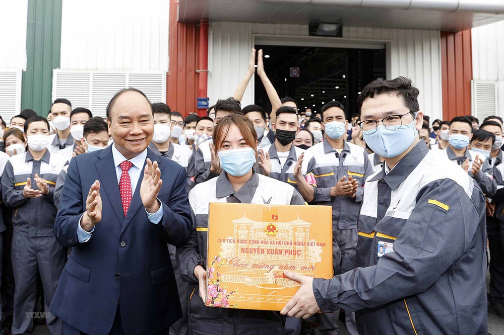 Chủ tịch nước Nguyễn Xuân Phúc tặng quà Tết công nhân lao động Công ty cổ phần sản xuất và kinh doanh VinFast. (Ảnh: TTXVN) Chủ tịch nước thăm, chúc Tết công nhân Công ty cổ phần sản xuất và kinh doanh Vinfast -0