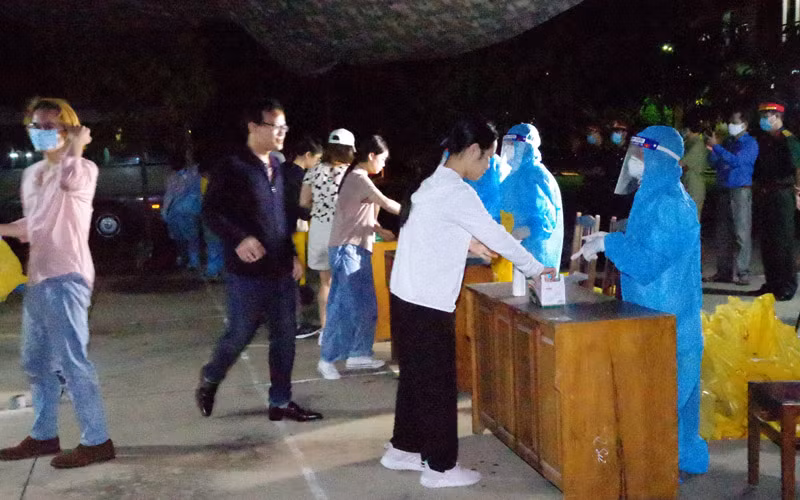 Các công dân nhận khẩu trang và làm thủ tục trước khi vào khu cách ly