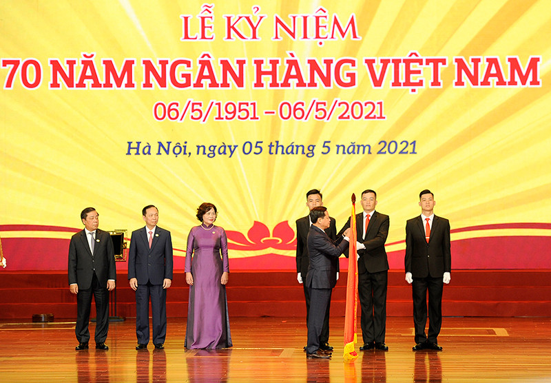 Phó Thủ tướng Lê Minh Khái gắn Huân chương Lao động hạng Nhất lên lá cờ truyền thống của Ngân hàng Nhà nước Việt Nam. Ảnh: ĐĂNG KHOA Tổng Bí thư Nguyễn Phú Trọng dự kỷ niệm 70 năm Ngày thành lập Ngân hàng Việt Nam -0