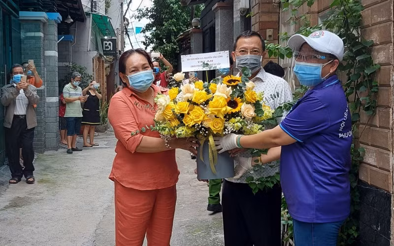 Người dân hẻm 415, đường Nguyễn Văn Công, phường 3, quận Gò Vấp tặng lẵng hoa tỏ lòng biết ơn chính quyền địa phương đã luôn đồng hành, quan tâm chăm lo trong suốt thời gian thực hiện cách ly y tế. (Ảnh: PHƯƠNG HOA)