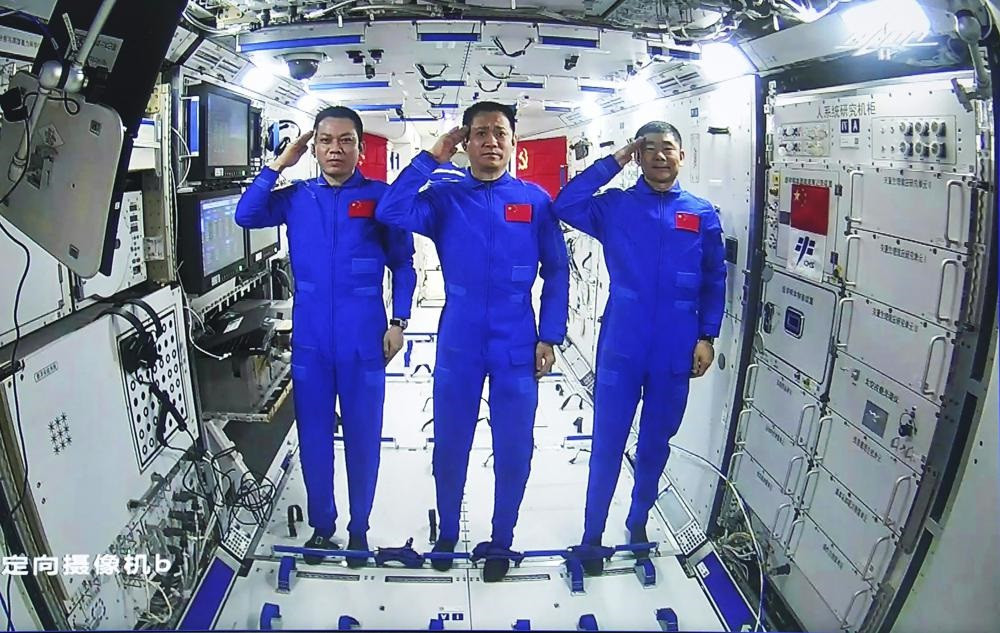 Các phi hành gia Trung Quốc, từ trái qua phải: Thang Hồng Ba, Nhiếp Hải Thắng và Lưu Bá Minh giơ tay chào trong cuộc trò chuyện video với Chủ tịch Trung Quốc Tập Cận Bình từ module lõi trạm vũ trụ Thiên Hòa của Trung Quốc vào ngày 23/6. Ảnh: Xinhua. Phi hành gia Trung Quốc lần đầu tiên đi bộ ngoài không gian trạm vũ trụ mới -0