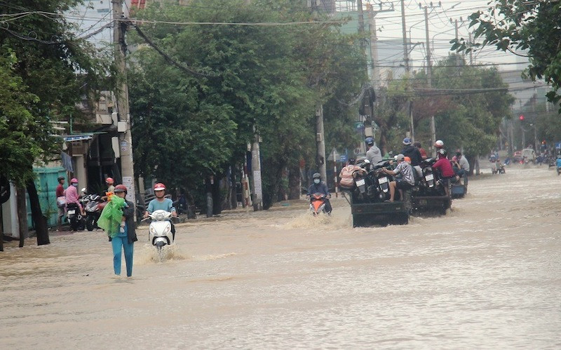 Tuyến đường Hùng Vương, thành phố Quy Nhơn bị ngập nặng, các xe máy phải tăng-bo qua điểm ngập bằng dịch vụ xe ba gác. Bão số 12 gây nhiều thiệt hại tại Bình Định -0
