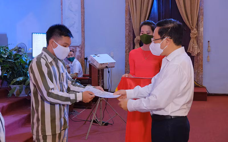 Đồng chí Phạm Bình Minh, Uỷ viên Bộ Chính trị, Phó Thủ tướng Chính phủ, Chủ tịch Hội đồng Tư vấn đặc xá trao Giấy chứng nhận đặc xá cho phạm nhân.