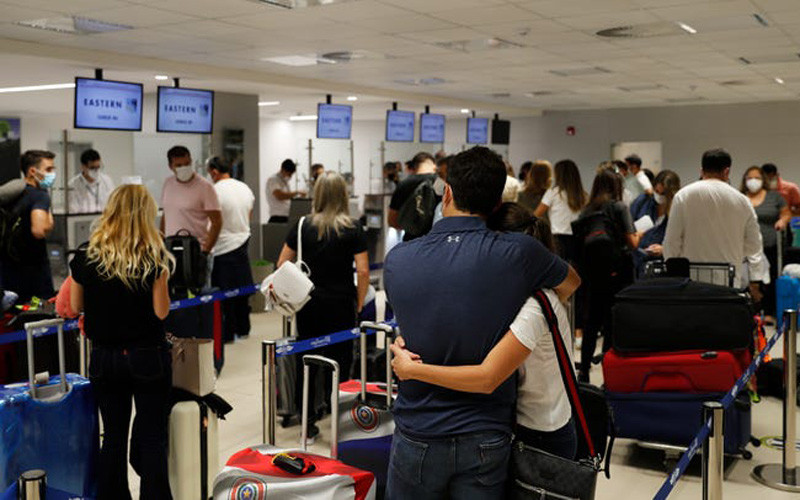 Người dân dứng xếp hàng chờ làm thủ tục tại sân bay Silvio Pettirosso (Paraguay) tới Miami. Nhiều người Mỹ Latinh tới Mỹ tiêm chủng có bạn bè hoặc người thân sống tại Mỹ và có thể giúp họ được tiêm chủng vaccine Covid-19. (Ảnh: AP) “Du lịch tiêm vaccine Covid-19”: có phải đòn bẩy du lịch? -0