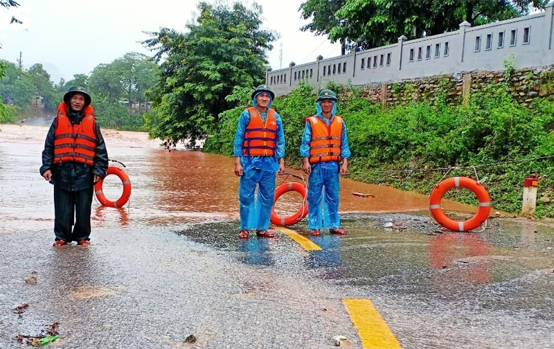 Chiến sĩ Đồn Biên phòng cửa khẩu quốc tế La Lay trực tại điểm giao thông cảnh báo người dân không đi qua vùng có nước chảy xiết. a1.jpg -0