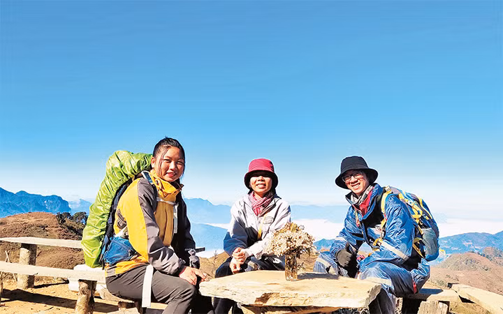 Lù Thị Gôn (trái) chụp ảnh cùng du khách trong chuyến leo núi Lảo Thẩn. Ảnh: K.H