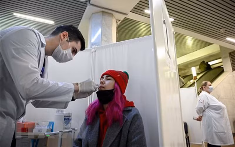 Nhân viên y tế lấy mẫu xét nghiệm COVID-19 cho người dân tại Moskva, Nga ngày 11/10/2021. (Ảnh: AFP/TTXVN)