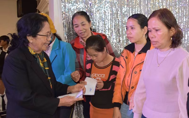 Giáo sư, bác sĩ Nguyễn Thị Ngọc Phượng, Phó Chủ tịch Trung ương Hội nạn nhân chất độc da cam/dioxin Việt Nam tặng quà cho các gia đình. Ảnh: Hà Phương