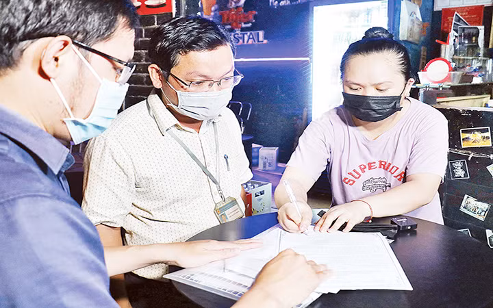 Đoàn kiểm tra quận Bình Thạnh ( TP. Hồ Chí Minh) tuyên truyền, yêu cầu cơ sở kinh doanh ký cam kết không vi phạm tiếng ồn. Ảnh | THÁI PHƯƠNG