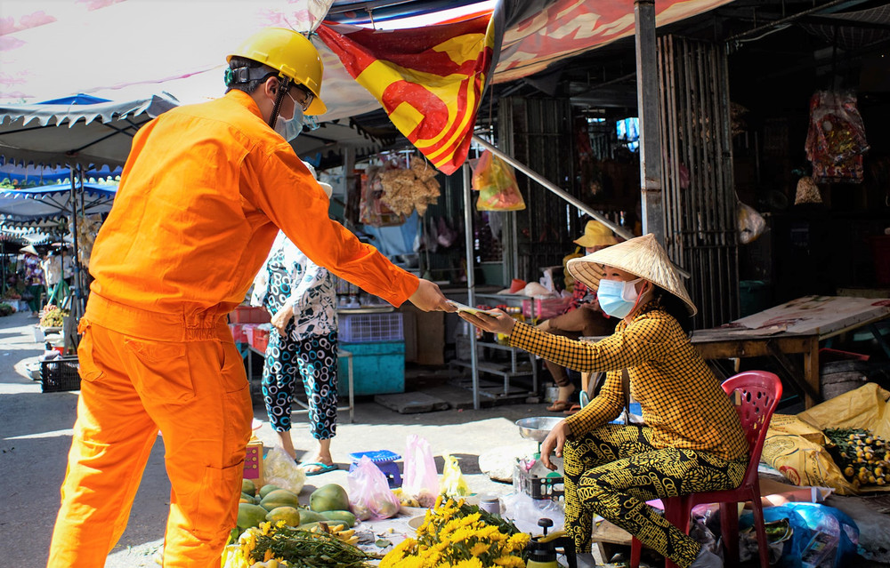Công nhân ngành điện Miền nam phát tờ rơi hướng dẫn người dân sử dụng điện tiết kiệm, hiệu quả trong thời gian giãn cách.