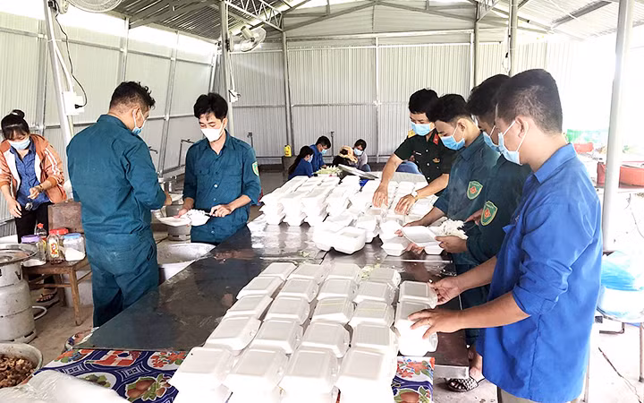 Các anh nuôi của bếp ăn Ban Chỉ huy quân sự huyện Châu Thành (Long An) chuẩn bị bữa ăn phục vụ người dân trong khu cách ly. Ảnh: VÂN ANH
