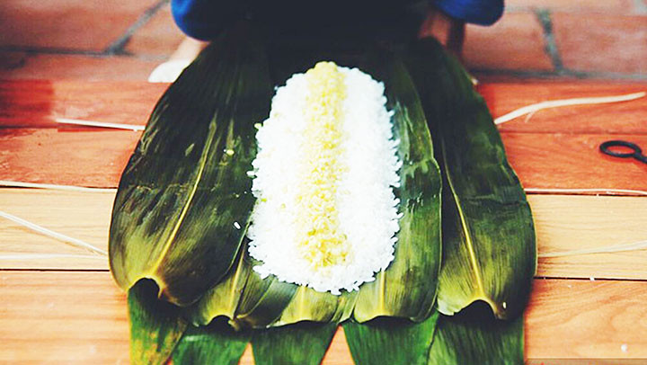 Gói bánh chưng bằng lá chít. Ảnh: SAOSTAR
