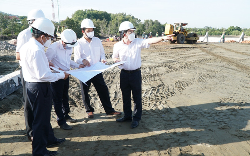 Ông Nguyễn Văn Hợp (thứ 2 từ trái qua) kiểm tra, đôn đốc các đơn vị thi công trên công trường thi công.