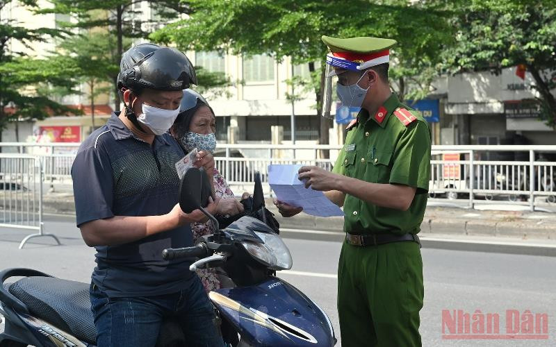 Lực lượng chức năng kiểm tra giấy đi đường của người dân tại chốt kiểm soát số 3, lối lên cầu Chương Dương. (Ảnh: DUY LINH) Bí thư Thành uỷ Hà Nội yêu cầu kiểm soát chặt các chốt ra, vào “vùng đỏ” -0
