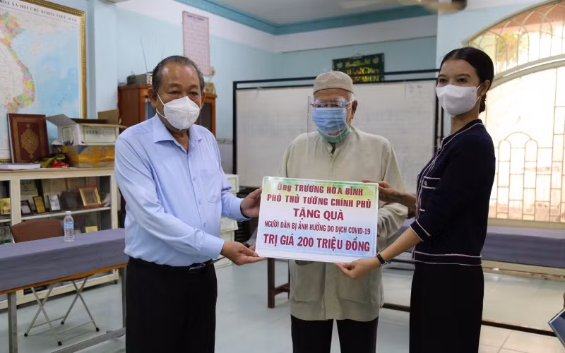 Phó Thủ tướng Thường trực Chính phủ Trương Hòa Bình và đại diện đơn vị tài trợ trao bảng tượng trưng, tặng quà cho ông Kim Sô, Giáo cả Thánh đường Anwar.