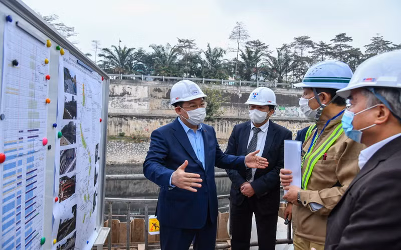 Đồng chí Vương Đình Huệ cùng các đồng chí lãnh đạo thành phố kiểm tra tại công trường xây dựng hệ thống cống bao cho sông Tô Lịch. (Ảnh: Duy Linh)