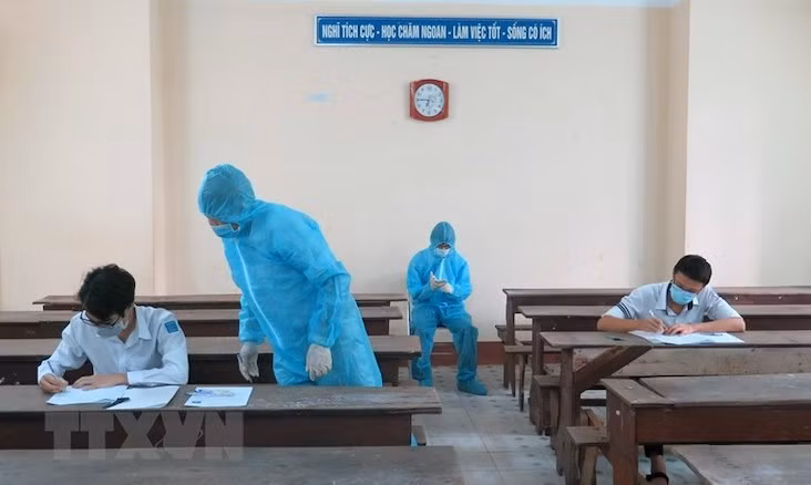 Hai thí sinh trong khu vực phong toả ở Phú Yên được bố trí phòng thi riêng, cán bộ coi thi mặc đồ bảo hộ. Ảnh: XUÂN TRIỆU/TTXVN